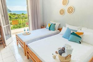 two beds in a room with a view of the ocean at Blue Maraçi 1 Beach Access nd Parking in Himare