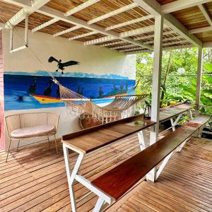 a hammock on a porch with a painting on the wall at Hotel Tama Lodge in Tamarindo