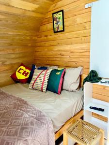 a room with a bed in a wooden cabin at Chalé Barril Recanto Monte Trigo in São Francisco do Sul