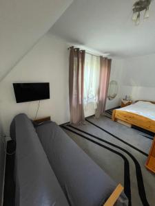 a bedroom with a bed and a flat screen tv at Myśliwskie Smaki U Tadka in Czeczewo