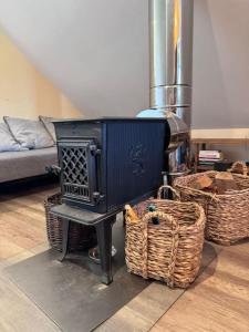a stove in a living room with baskets on the floor at Charming studio by the river in Uście Gorlickie