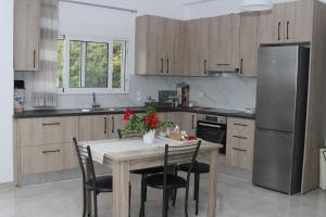 a kitchen with a table with chairs and a refrigerator at Vagelis Nemea apartments in Neméa