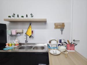 a kitchen with a sink and a counter top at Cozy FamiLee Homestay in Simpang Ampat +12 photos