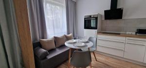 a kitchen with a couch and a small table in a room at Zentrum Apartment - OLED TV - PS4 - Balkon - Parking in Chemnitz +4 photos