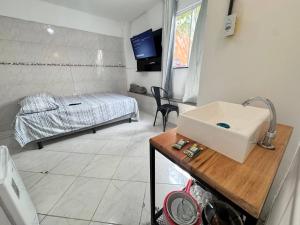 un bagno con un lavandino e un letto in una stanza di Ap próximo ao Arco com garagem e ar sem TV a Sobral