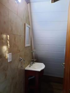 a bathroom with a sink and a mirror at Cabañas Roma in Sierra de la Ventana +2 photos