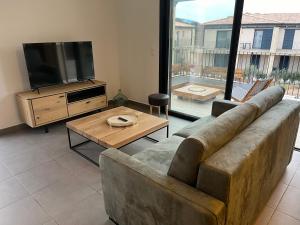 Una sala de estar con un sofá y un televisor de pantalla plana. en Dell Edera, en Bonifacio