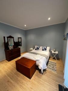 a bedroom with a large bed and a mirror at The Blue House in Cannon Rocks