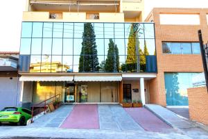 a building with a green car parked in front of it at Athens Airport Living spaces in Spáta