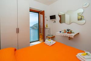 a bedroom with an orange bed and a balcony at Dependance Rosetta in Minori
