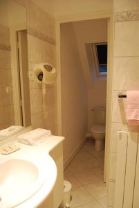 a bathroom with a sink and a toilet at Hostellerie de la Motte jean in Saint-Coulomb