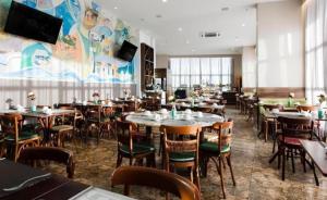 a dining room with tables and chairs in a restaurant at Hotel Natal Plaza com piscina, academia, 100m da praia de Ponta Neg in Natal