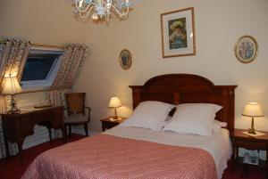 a bedroom with a bed and two lamps and a window at Hostellerie de la Motte jean in Saint-Coulomb