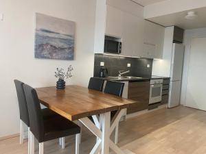 a kitchen with a wooden table and chairs in a room at First Aparthotel Olive in Rovaniemi