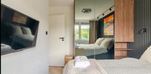 ein Schlafzimmer mit zwei Betten und einem Spiegel in der Unterkunft Oliwa luxury apartment, free parking, high speed internet in Danzig