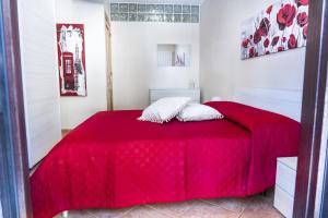 a red bed with two pillows on top of it at B&B Marilù in Celano