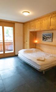 a large bed in a room with a large window at Résidence Grenon in Crans-Montana