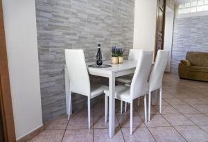 a dining room with a white table and white chairs at B&B Marilù in Celano