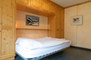 a bedroom with a bed in a wooden wall at Résidence Grenon in Crans-Montana