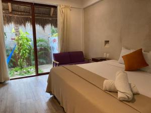 a bedroom with a large bed and a large window at Hotel Pelecanus Suites Holbox in Holbox Island +58 photos
