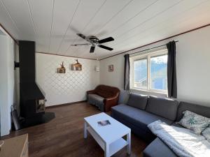 a living room with a couch and a ceiling fan at Cosy House in Swedish Lapland in Överkalix