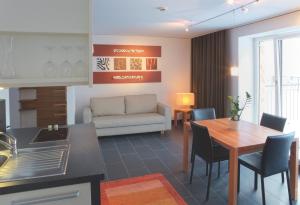 eine Küche und ein Wohnzimmer mit einem Tisch und einem Sofa in der Unterkunft Pepis Skihotel in Sankt Anton am Arlberg