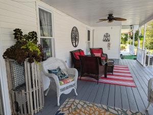 a porch with chairs and a table and a fan at The Parrsboro Mansion Inn in Parrsboro