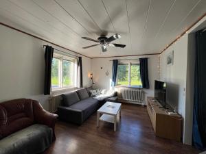 a living room with a couch and a ceiling fan at Cosy House in Swedish Lapland in Överkalix