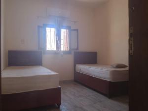 ダハブにある2 Bedroom Houseの窓が2つある部屋にベッドが2つある