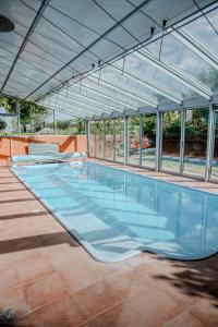 a large swimming pool with an open roof at Edi Birtok in Oroszló