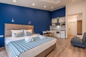 a bedroom with a large bed and a blue wall at New Gudauri Geoflats in Gudauri
