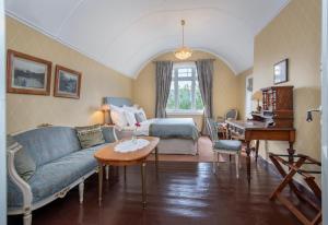 a living room with a couch and a bed and a piano at Jervell 4 Bnb in Ålesund