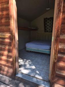 a door to a room with a bed in it at Sleeping Cabin East, roughing it gently in Verdure