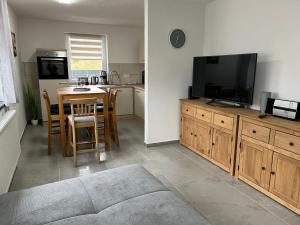 a living room with a television and a table with chairs at Ferienhaus Anton Günther in Bernsbach