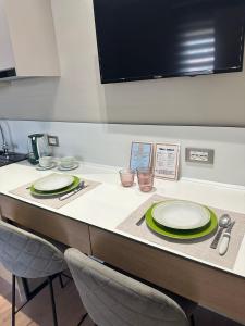 a table with two chairs and plates on it at Klei’s Daily Apartment in Tirana