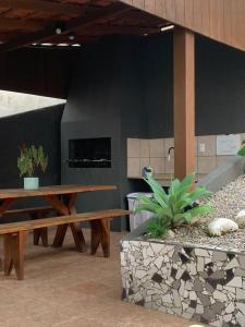 a room with a bench and a table and plants at Pousada Latitude 27 Bombinhas in Bombinhas