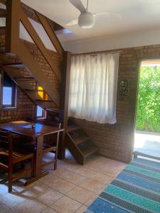 a dining room with a table and a staircase at Pousada Latitude 27 Bombinhas in Bombinhas