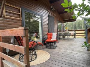 a porch of a cabin with chairs and a table at La Clairiere - Erezee- 3 bedroom chalet in Érezée +12 photos