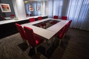 a conference room with a white table and red chairs at Jinjiang Inn - Shenzhen Airport in Bao'an