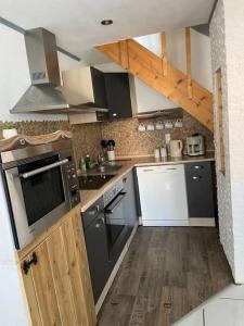 a kitchen with black and white appliances and wooden floors at Maisonette Edna in Mechernich