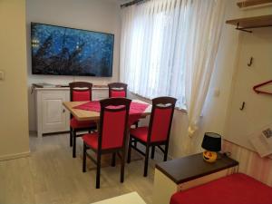 a dining room with a table and red chairs at Ferienwohnung Baer 2 in Hoppegarten