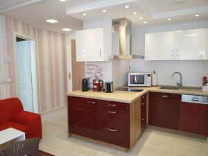 a kitchen with brown cabinets and a microwave at Ferienwohnung Baer 2 in Hoppegarten