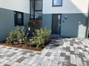 a house with a courtyard with plants in front of it at Ferienwohnung Am Hochkelberg in Bereborn