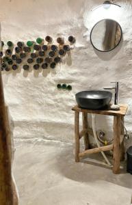 Un baño con un lavabo y un espejo en la pared. en Janki's Commune - An Earthen Stay Amidst Old Manali, en Manali