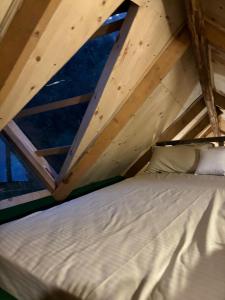 una cama en una habitación con una ventana grande en Janki's Commune - An Earthen Stay Amidst Old Manali, en Manali 6 fotos más