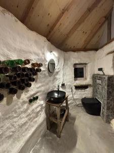 Una habitación con un lavabo y botellas de vino en la pared. en Janki's Commune - An Earthen Stay Amidst Old Manali, en Manali