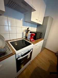 a kitchen with white cabinets and a stove top oven at Etoile in Ault