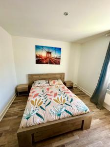 a bedroom with a bed and a painting on the wall at Etoile in Ault +1 photo