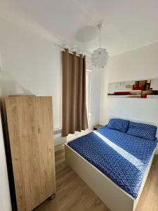 a bedroom with a bed with blue sheets and a window at Etoile in Ault