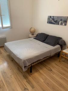 a bed in a room with a wooden floor at Vacances et travail in Serrières-de-Briord +19 photos